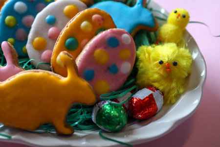 Close up of Easter cookies in the shape of rabbit and eggs with little chicken on the plate at home...