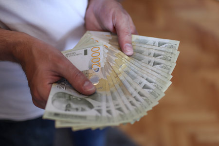 Male hands holding a pile of money. Serbian dinar paper currency, 2000 dinars value