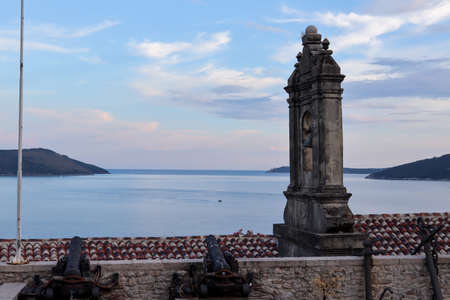 Herceg Novi, Montenegro - July 17, 2021 Ancient anchors and cannons stored in the Maritime Museum, an old bell tower and a stunning view of the Bay of Kotor behind itのeditorial素材