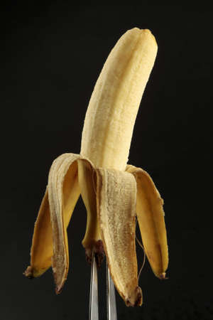 Peeled baby banana on black backgroundの写真素材