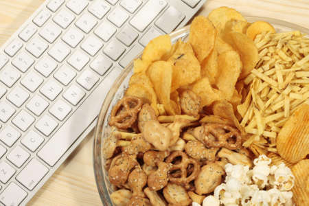 Various types of snacks near keyboardの写真素材