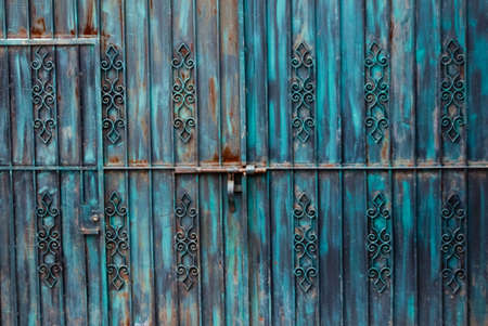 Rusted blue iron gateway with doorの写真素材