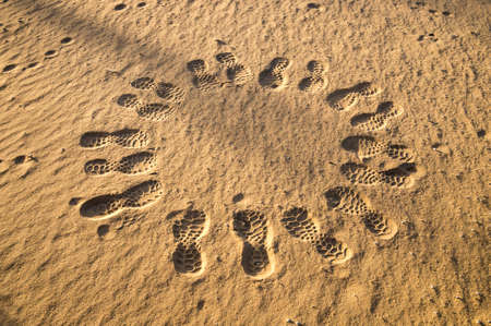 Circle of footprints in desert at duskの写真素材