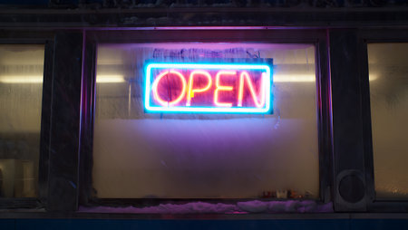 Open sign on a shop window at night in New York City.の素材