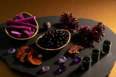 spa still life with purple candles and black stones on brown backgroundの素材