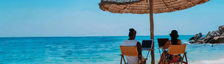 A couple working remotely from a beach, their laptops connected to virtual meeting rooms under a shaded umbrellaの素材