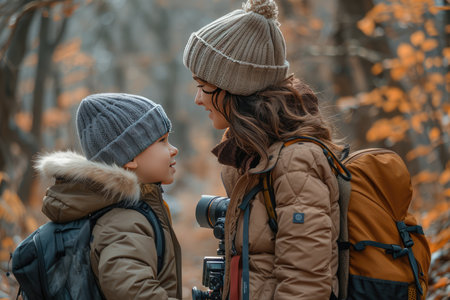 There is a mother and her son in the picture. They are wearing warm clothes and look happy. They are probably on a hike in the woods.の素材
