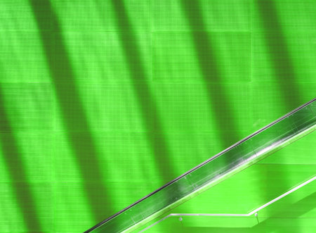 Green absorber panels pattern with escalator, railing and the water shading on the wallの写真素材