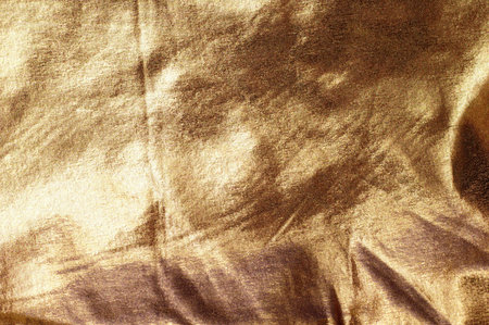 Abstract background of wrinkled gold brocade fabric