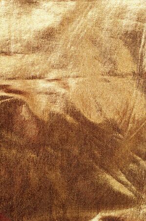 Abstract background of wrinkled gold brocade fabricの写真素材