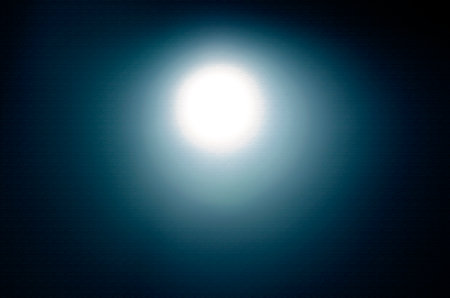 Moon on a blue background. The sun is reflected in the lens.の写真素材