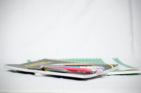 Pencils and notebook on a white background with space for textの写真素材