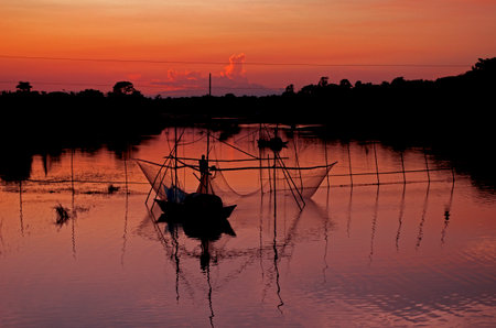 Fishing boat on the river at sunset in the countryside of Thailandの写真素材