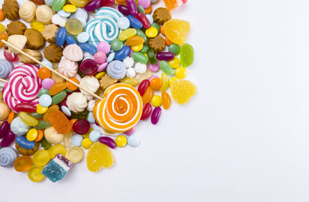 Colorful candies on white background. Top view with copy space