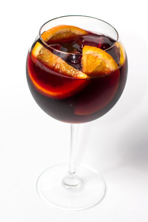 Raspberry lemonade jug with two wine glasses, orange citrus slices. wooden table background. top...