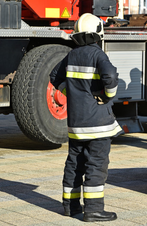 Firefighter stands next to a vehicleの写真素材