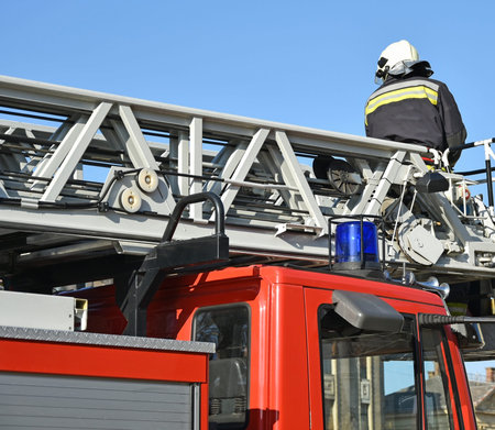 Firefighter works on the top of a fire truck