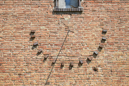 Sun-dial on the brick wall of an old buildingの写真素材