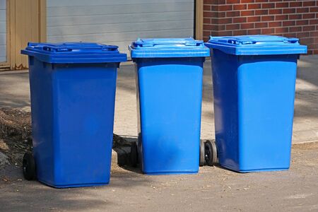Blue garbage cans on the street in a rowの写真素材