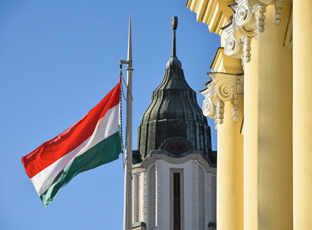 The hungarian national flag next to the Great church in Debrecen city
