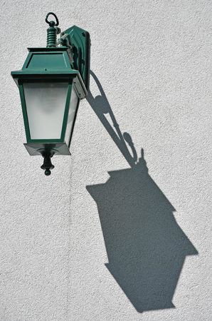 Green ornate light on the wall of a buildingの写真素材