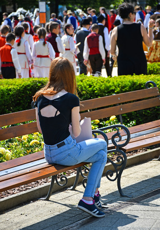 Young woman sits on a park benchの写真素材