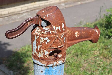 Old rusty pump well on the streetの写真素材