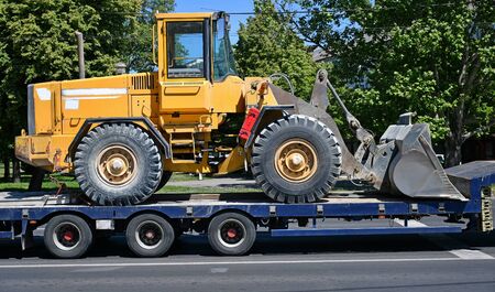Excavator transported on a trailerの写真素材