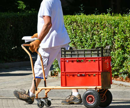 Delivery man pulling some food box on the streetの写真素材