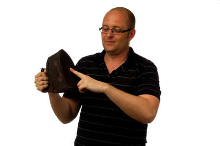 Funny amazed man in glasses and causial shirt holding old rusty iron isolated on white backgroundの写真素材
