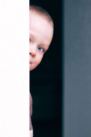 little beautiful child playing hide smiles thinkingの写真素材