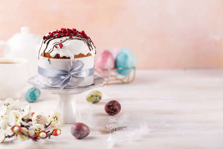 Spring Easter cake with white icing and sugar decor and easter eggs on the white table. easter conceptの写真素材