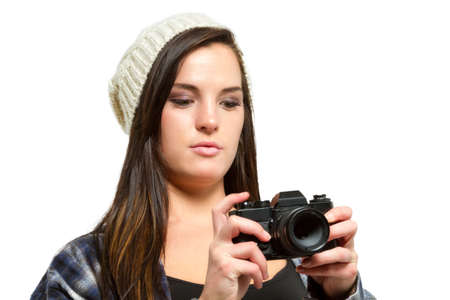 Young woman with brown hair holds camera and takes picturesの写真素材