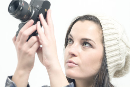 Young woman with brown hair holds camera and takes pictures