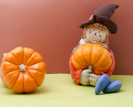 Scarecrow rag doll holds a pumpkinの写真素材