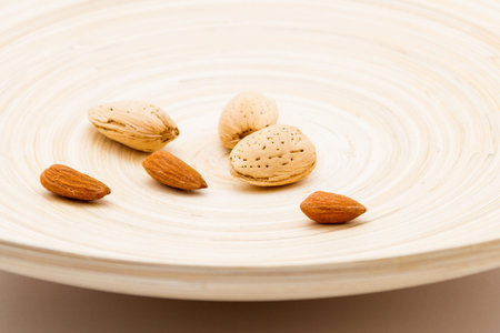 Shelled and unshelled Almond nuts served on a dish