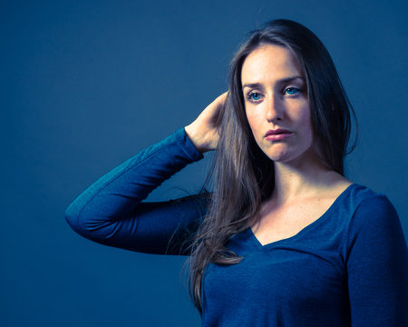 Slender caucasian female with somber or gloomy expression