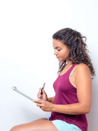 Young lady reviews papers while seated concept.の写真素材