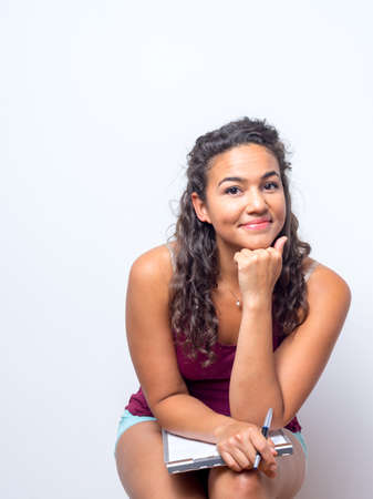 Female with warm and friendly smile holding a clipboard and writing penの写真素材