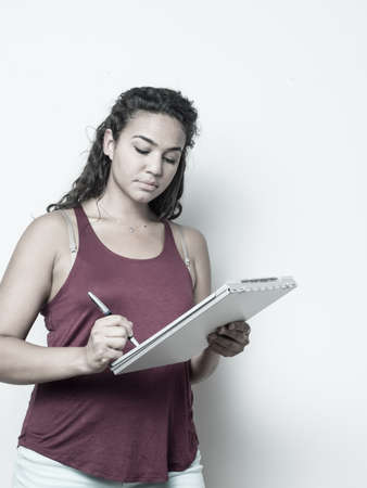 College age student holding clipboard taking notes conceptの写真素材