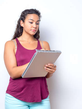 College age student holding clipboard taking notes conceptの写真素材