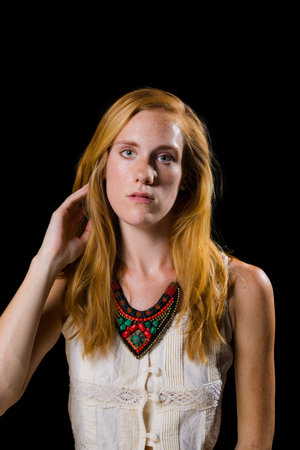 Attractive strawberry blonde hair and blue eyes female on isolated black backgroundの写真素材