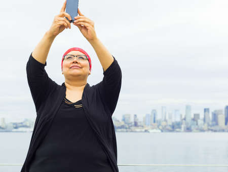 Woman takes in downtown scenery with some selfies.の写真素材