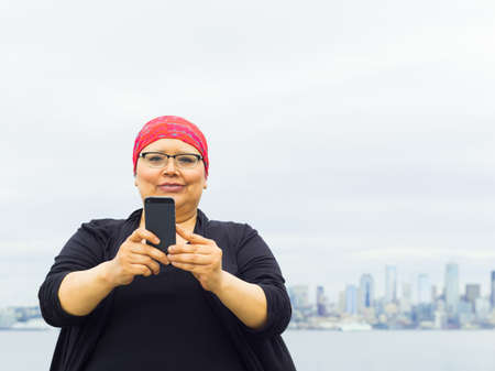 Woman takes in downtown scenery with some selfies.の写真素材