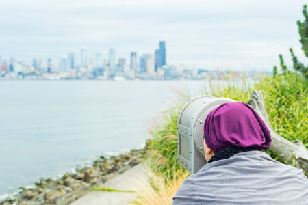 Beautiful middle aged woman using a telescopeの写真素材
