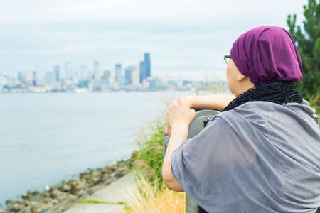 Beautiful middle aged woman using a telescopeの写真素材