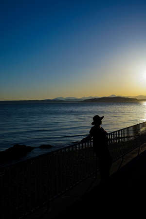 Female Wearing Hat At Beach In Thought Silhouetteの写真素材