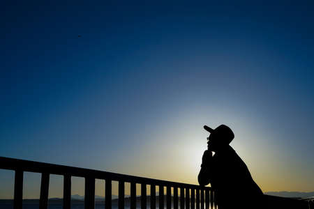 Female Wearing Hat At Beach In Thought Silhouetteの写真素材