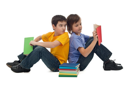 Two happy boys sitting on the floor and reading books