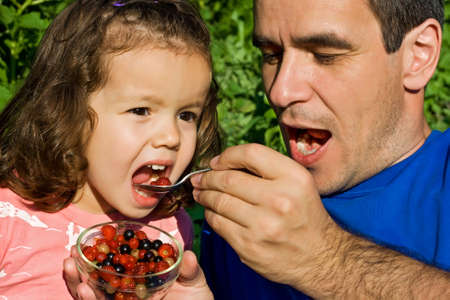 Father giving fresh fruits to his little girlの写真素材